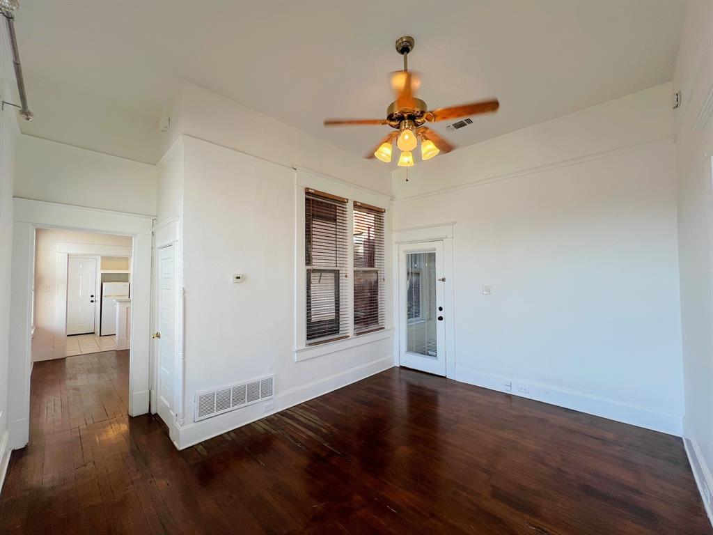 109 Northwest 20th Street, Unit 201 Fort Worth, TX 76164 - Photo 11 of 21 a view of an empty room with wooden floor and a window
