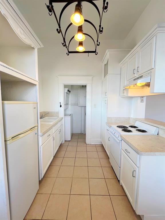 109 Northwest 20th Street, Unit 201 Fort Worth, TX 76164 - Photo 12 of 21 a kitchen with white cabinets appliances and a sink