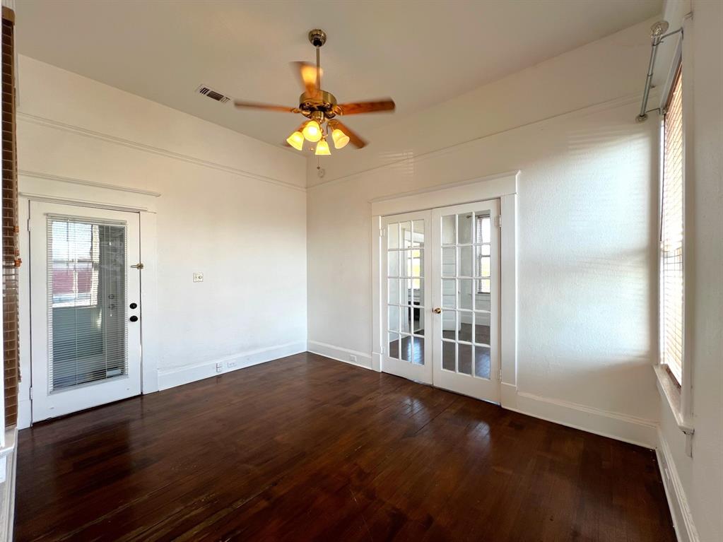 109 Northwest 20th Street, Unit 201 Fort Worth, TX 76164 - Photo 13 of 21 an empty room with wooden floor and windows