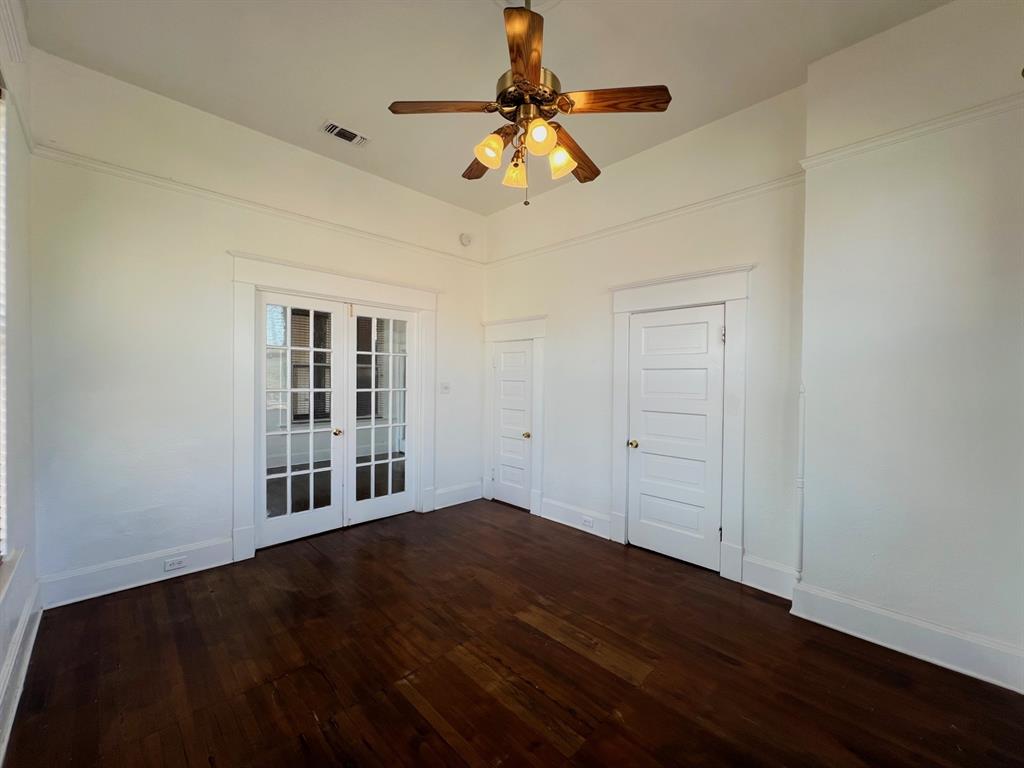 109 Northwest 20th Street, Unit 201 Fort Worth, TX 76164 - Photo 15 of 21 a view of empty room with wooden floor and fan