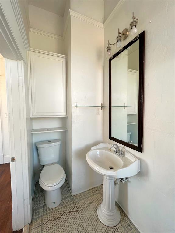 109 Northwest 20th Street, Unit 201 Fort Worth, TX 76164 - Photo 16 of 21 a bathroom with a toilet a sink and mirror