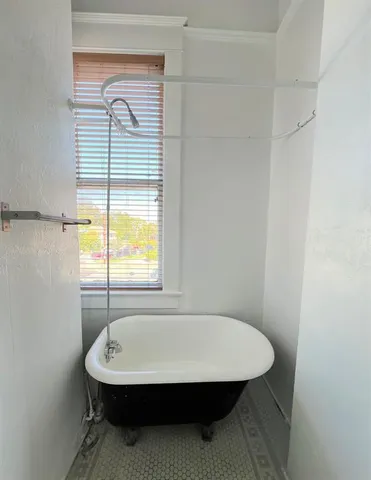 a bathroom with a sink a bathtub and next to a window