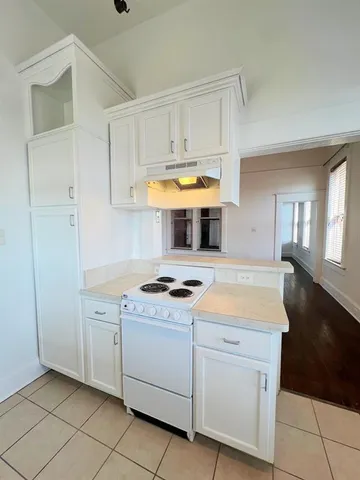 a kitchen with white cabinets and appliances