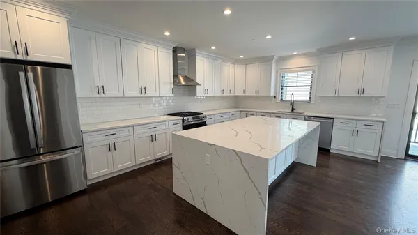 a kitchen that has a sink a counter top space stainless steel appliances and cabinets