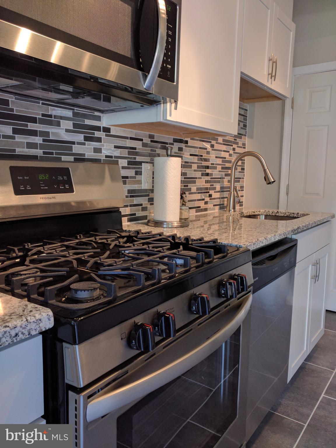 1976 Haselmere Road Dundalk, MD 21222 - Photo 9 of 28 a stove sitting inside of a kitchen with granite countertop