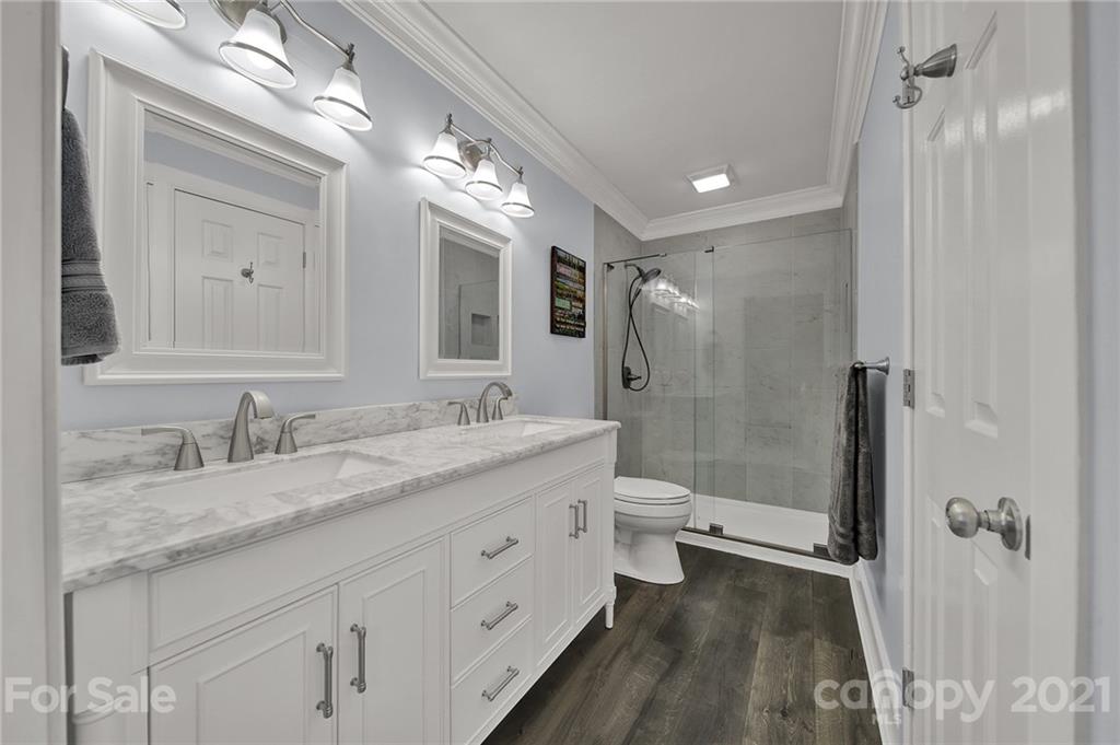 8999 West Meadow Ridge Road Indian Land, SC 29707 - Photo 11 of 28 a bathroom with a granite countertop double vanity sink a mirror and a toilet