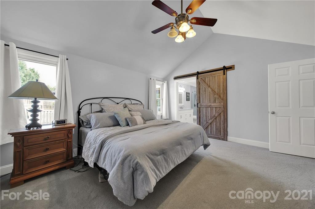 8999 West Meadow Ridge Road Indian Land, SC 29707 - Photo 12 of 28 a bedroom with a bed and a chandelier