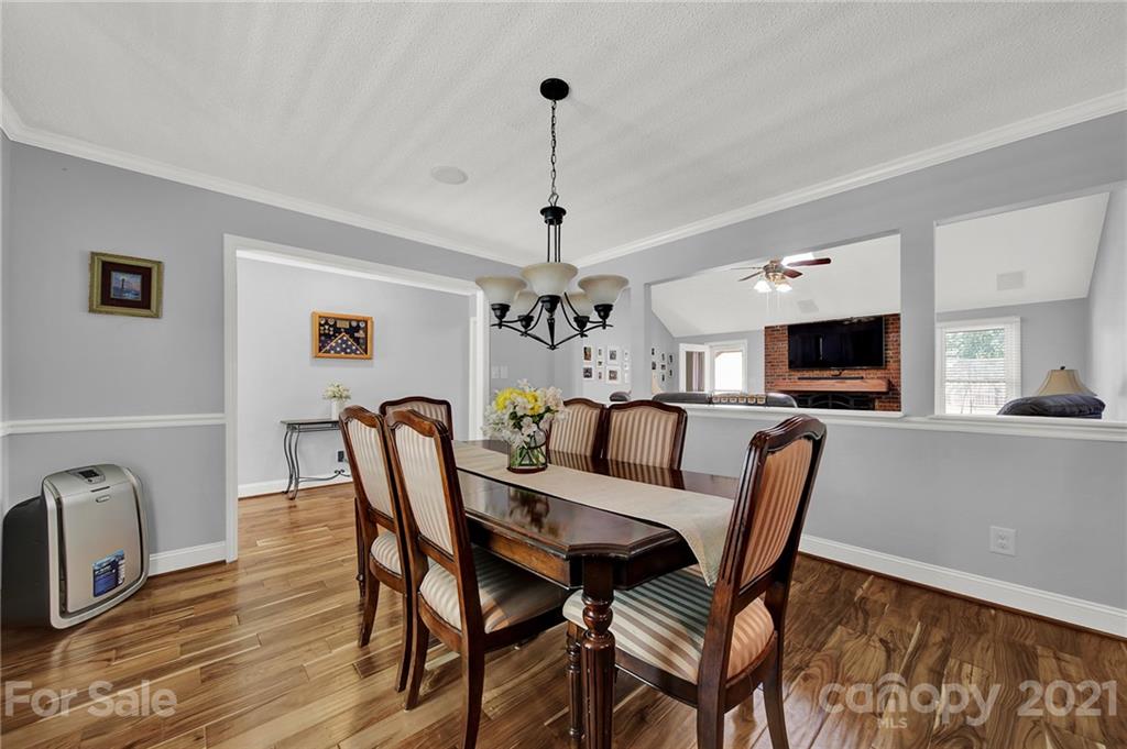 8999 West Meadow Ridge Road Indian Land, SC 29707 - Photo 19 of 28 a view of a dining room with furniture wooden floor and chandelier