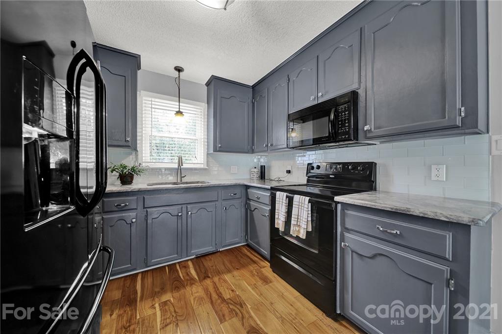 8999 West Meadow Ridge Road Indian Land, SC 29707 - Photo 21 of 28 a kitchen with granite countertop a sink stainless steel appliances and cabinets