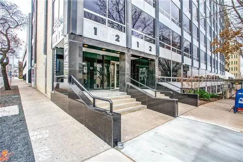 a bedroom with a bed and a large window with outer view
