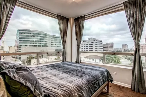 a bedroom with a large bed and a large window with outer view