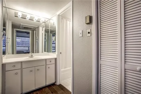 a bedroom with a bed a large window with table and chair