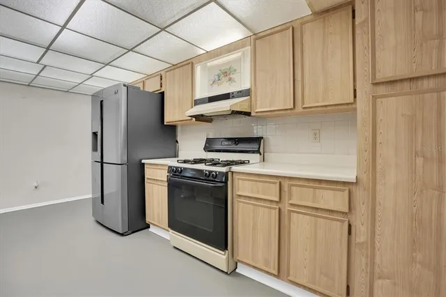 a kitchen with stainless steel appliances granite countertop white cabinets and a refrigerator