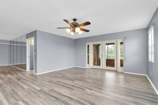 a view of an empty room with window and wooden floor