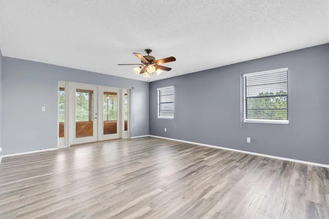 a view of an empty room with a window and wooden floor