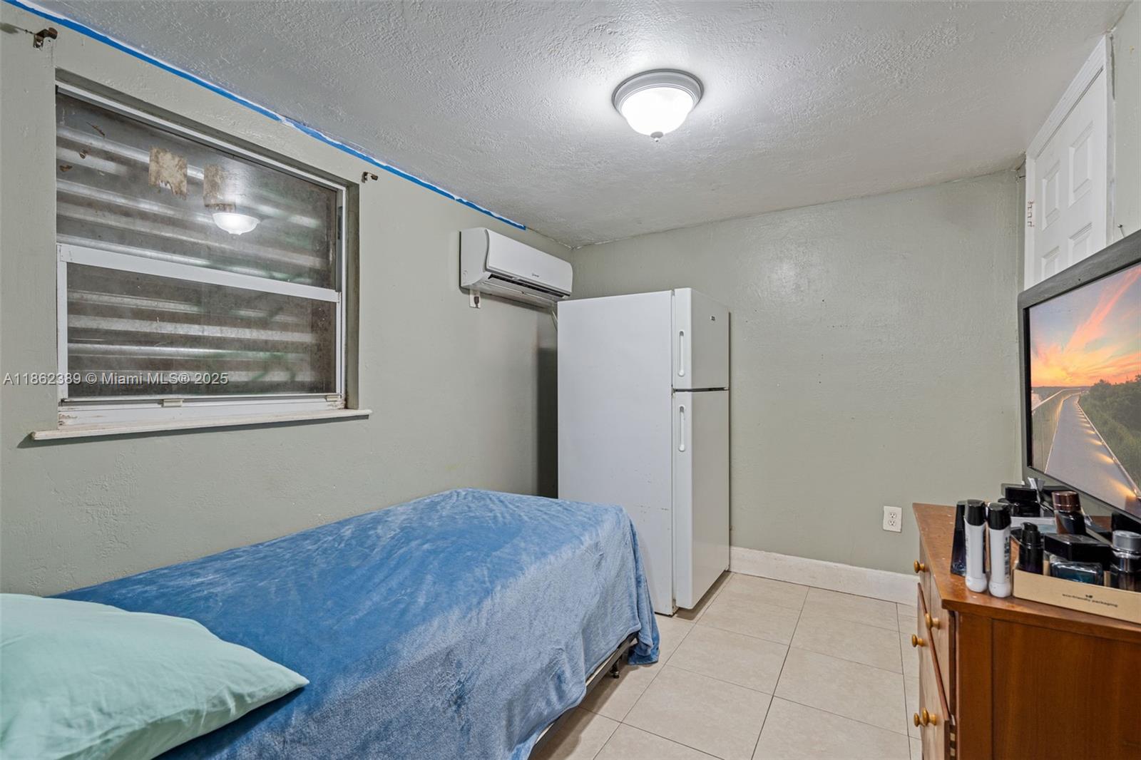 6233 Rodman Street Hollywood, FL 33023 - Photo 30 of 39 a bedroom with a bed and a flat screen tv