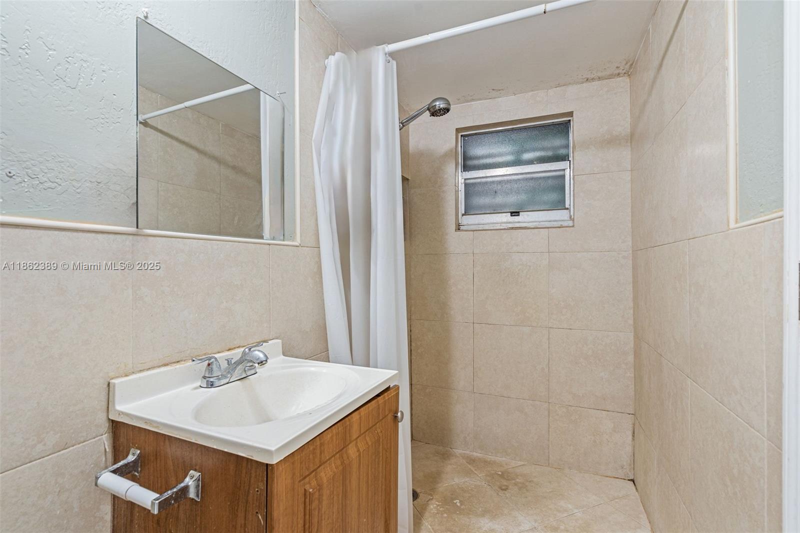 6233 Rodman Street Hollywood, FL 33023 - Photo 32 of 39 a bathroom with a sink and a mirror