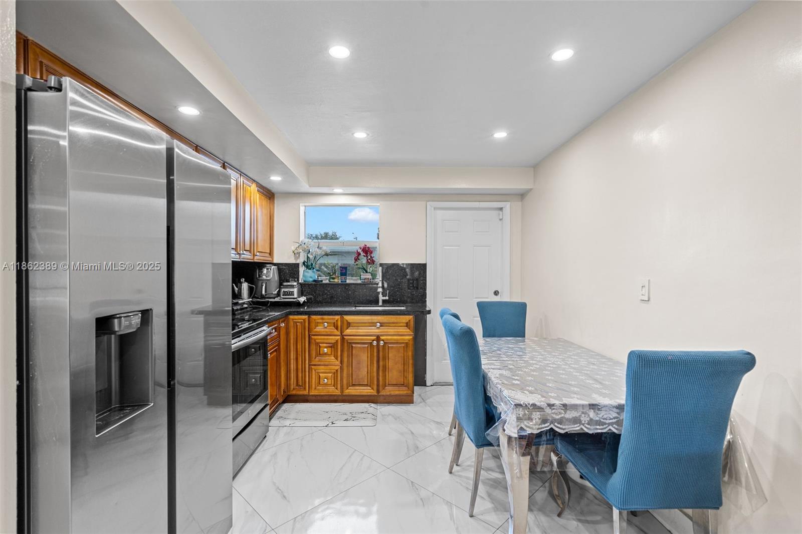 6233 Rodman Street Hollywood, FL 33023 - Photo 10 of 39 a kitchen with stainless steel appliances kitchen island granite countertop a refrigerator and a stove top oven