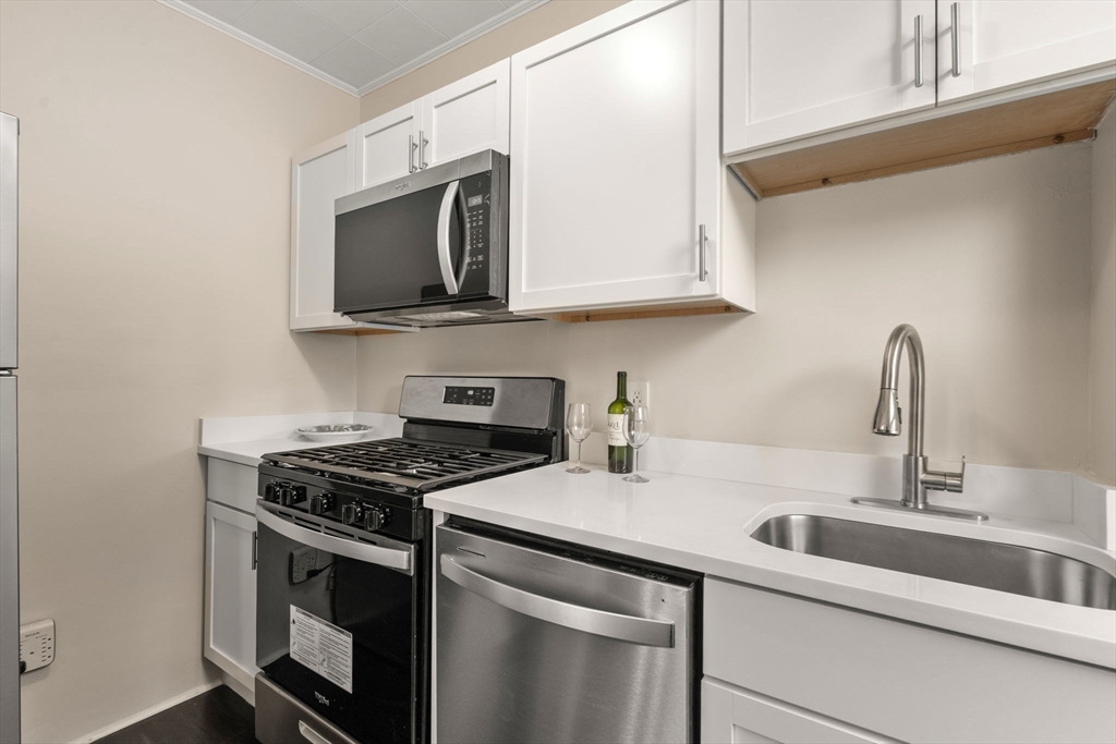 100 Magazine Street, Unit 2 Cambridge, MA 02139 - Photo 6 of 15 a kitchen with stainless steel appliances granite countertop a sink stove and microwave