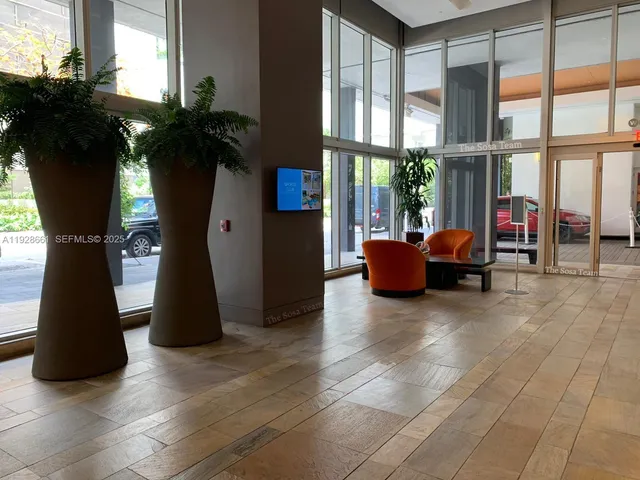a living room with furniture and a floor to ceiling window