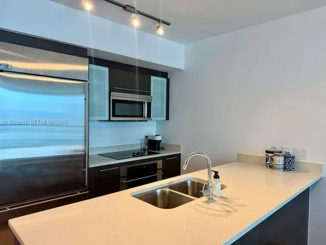 a kitchen with granite countertop a sink and stainless steel appliances