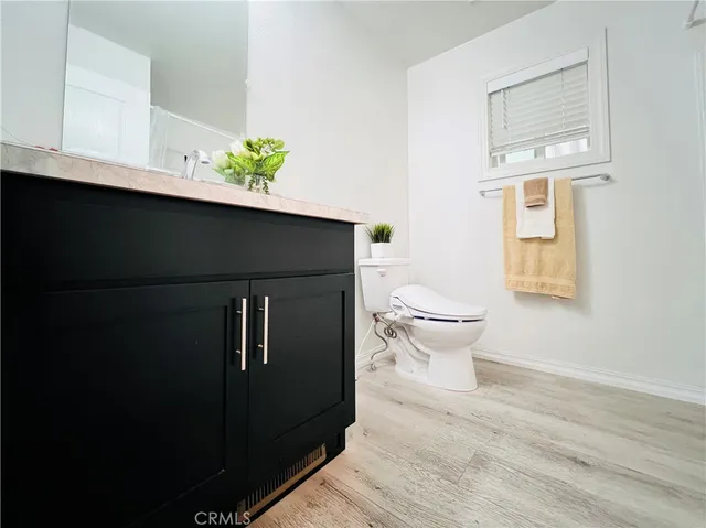 a view of a kitchen with white cabinets and wooden floor