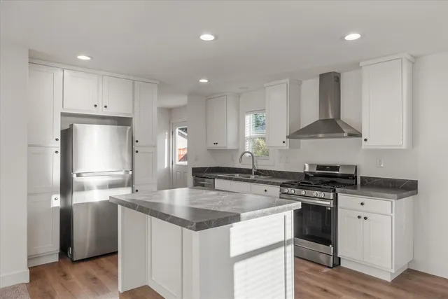 a kitchen with stainless steel appliances granite countertop a sink stove and refrigerator