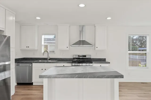 a kitchen with granite countertop a sink a stove and cabinets