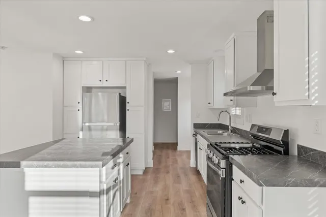 a kitchen with stainless steel appliances granite countertop a sink stove and refrigerator