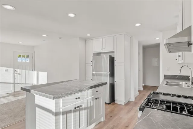 a kitchen with stainless steel appliances a stove a sink and a refrigerator