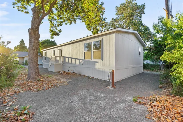 a view of a house with a yard and wooden fence