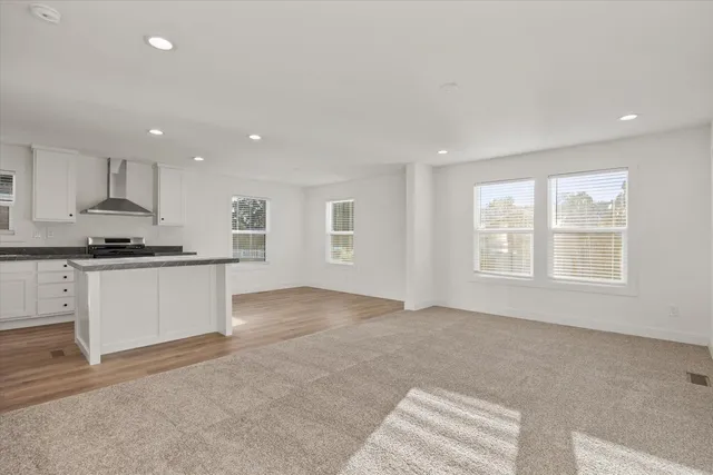 a view of kitchen with kitchen island a sink wooden floor and a stove