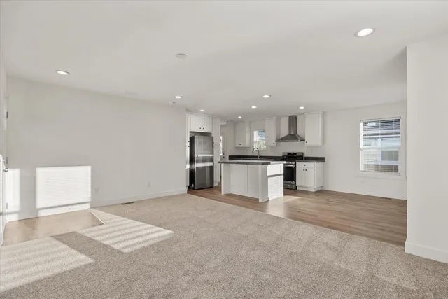 a view of kitchen with kitchen island white cabinets and refrigerator