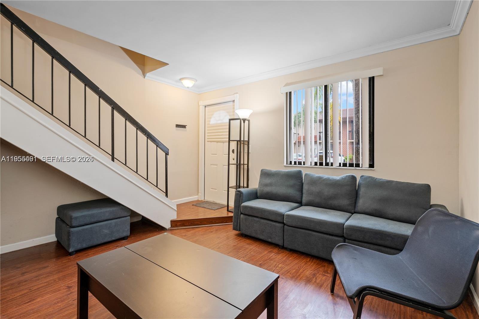 1927 Southwest 107th Avenue, Unit 306 Miami, FL 33165 - Photo 4 of 23 a living room with furniture stairs and a window