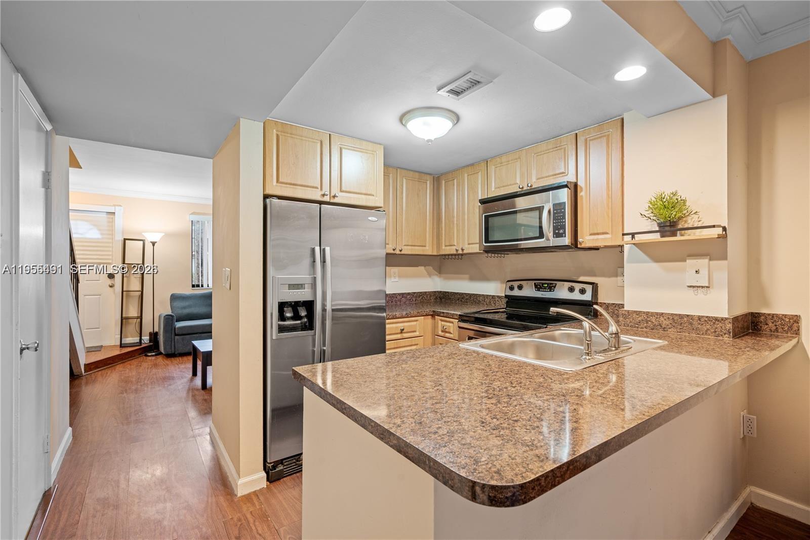 1927 Southwest 107th Avenue, Unit 306 Miami, FL 33165 - Photo 6 of 23 a kitchen with stainless steel appliances granite countertop a sink refrigerator and microwave