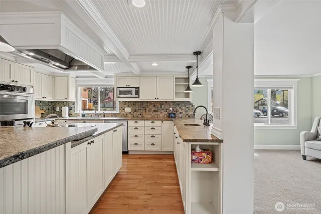 a kitchen with stainless steel appliances granite countertop a sink stove and cabinets