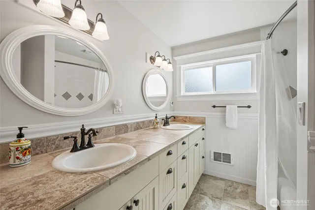 a bathroom with a granite countertop double vanity sinks and a mirror
