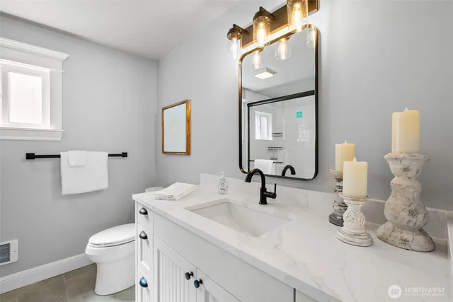 a bathroom with a toilet sink and mirror