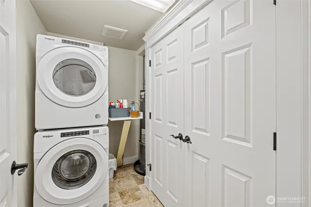 a utility room with dryer washer and a view of bathroom