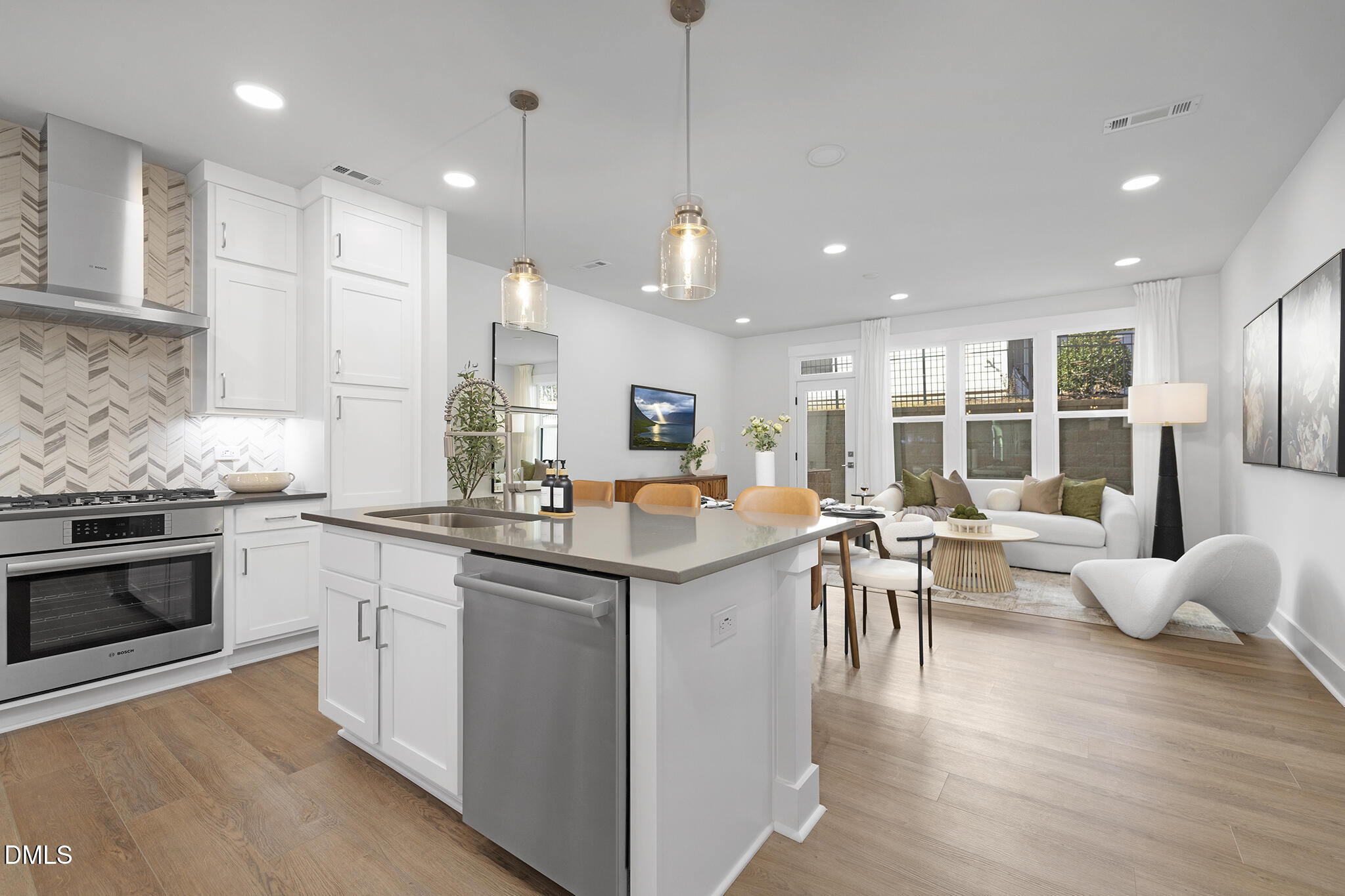 a kitchen that has a lot of cabinets a sink a stove and wooden floor