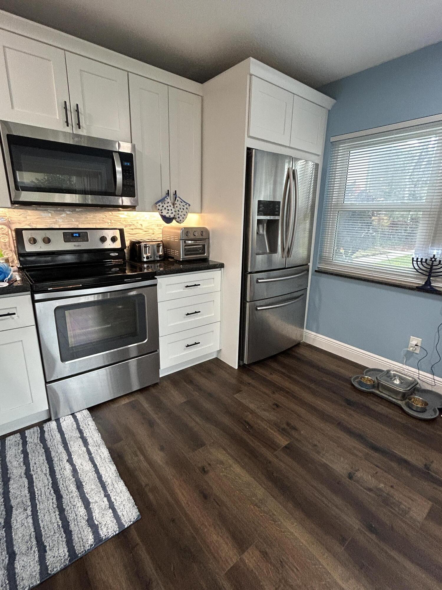 4802 Roxbury Court Boynton Beach, FL 33436 - Photo 11 of 23 a kitchen with granite countertop stainless steel appliances and wooden cabinets
