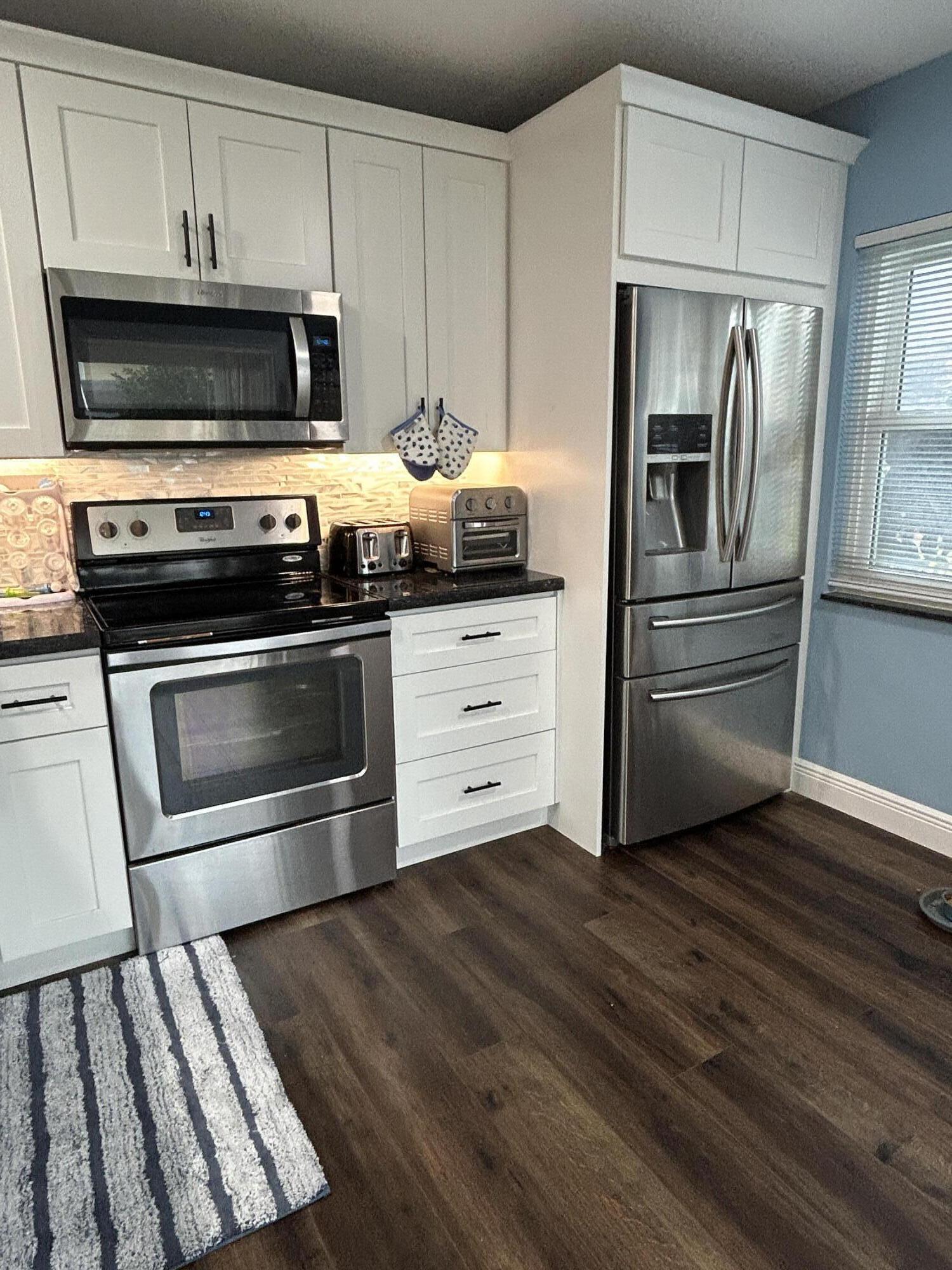 4802 Roxbury Court Boynton Beach, FL 33436 - Photo 2 of 23 a kitchen with granite countertop a stove and a microwave