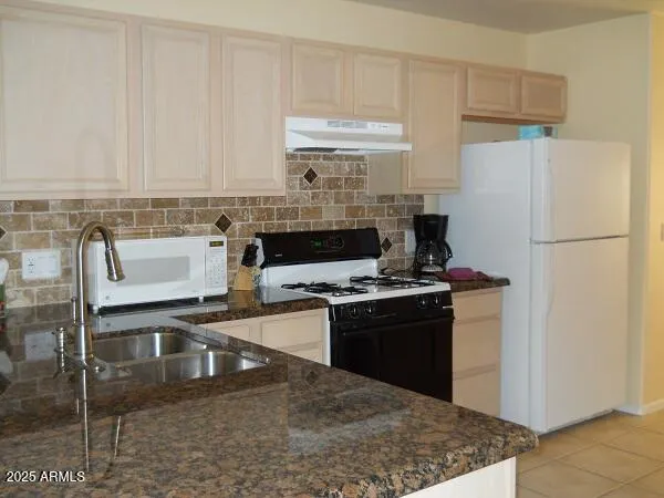 a kitchen with stainless steel appliances granite countertop a stove a refrigerator and a sink