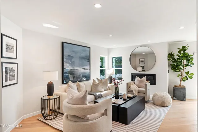 a living room with furniture a large window and a potted plant