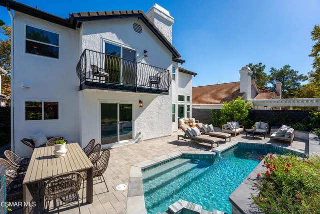 a view of a patio with couches table and chairs with potted plants and wooden fence