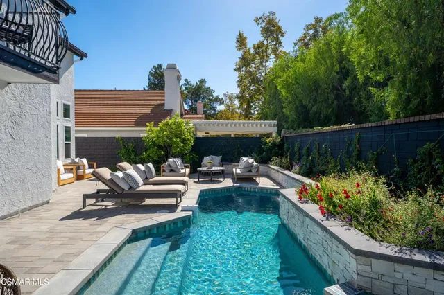 a living room with furniture a rug and kitchen view