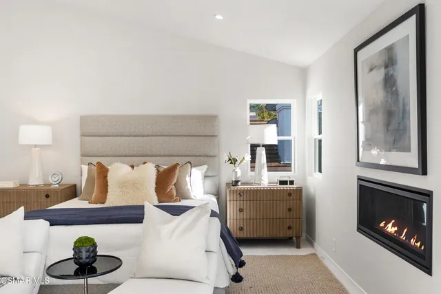 a bedroom with a large bed and a flat tv screen on dresser