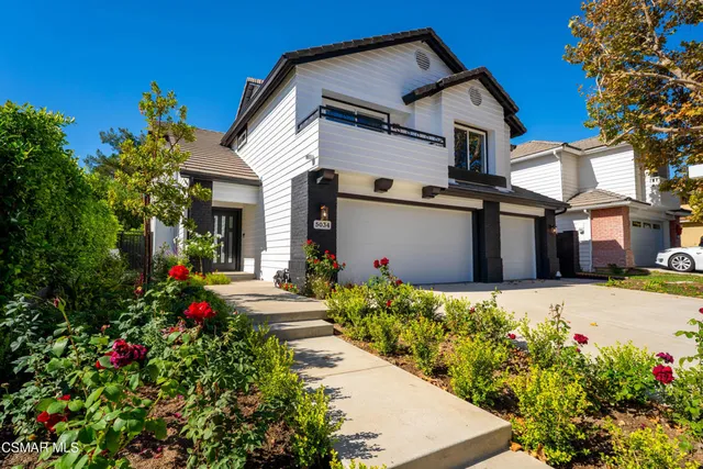 a front view of a house with a flower garden