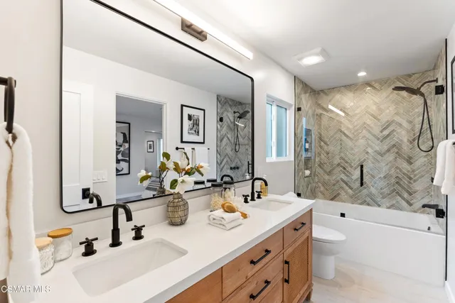 a view of a patio with couches table and chairs under an umbrella with a fire pit