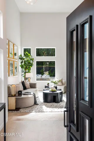a living room with furniture and large windows